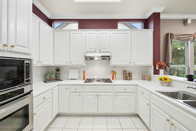 130 Enchanted Dr, Georgetown, TX 78633 - kitchen with appliances with stainless steel finishes, ornamental molding, tasteful backsplash, under cabinet range hood, and white cabinets