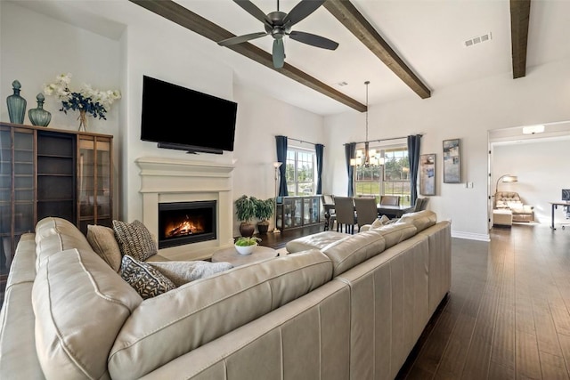 147 William Hersee Dr, Bastrop, TX 78602 - living area featuring ceiling fan, beamed ceiling, a warm lit fireplace, a chandelier, and dark wood-type flooring