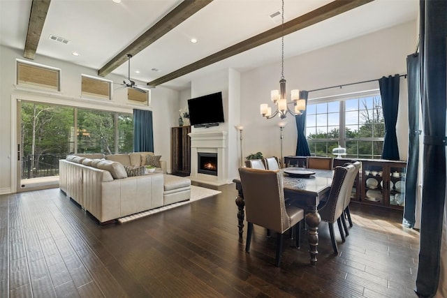147 William Hersee Dr, Bastrop, TX 78602 - dining space featuring beamed ceiling, a lit fireplace, healthy amount of natural light, a ceiling fan, and dark wood-style flooring