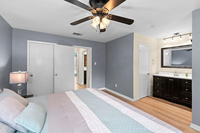 907 Great Oaks Cv, Round Rock, TX 78681 - bedroom with light wood-style floors, connected bathroom, and a ceiling fan