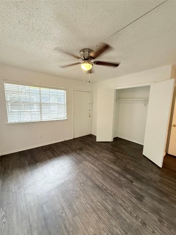 2704 Salado St Unit 207, Austin, TX 78705 - unfurnished bedroom with a textured ceiling, dark wood-style floors, a ceiling fan, and a closet