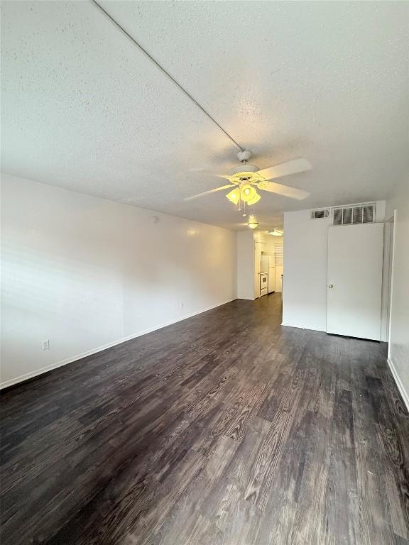 2704 Salado St Unit 207, Austin, TX 78705 - unfurnished living room with dark wood-style flooring, a textured ceiling, and a ceiling fan