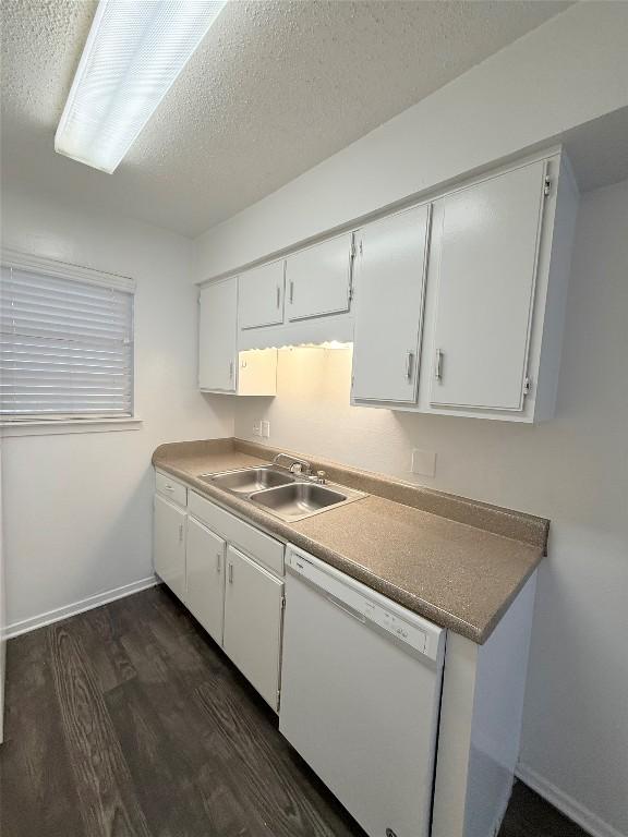 2704 Salado St Unit 207, Austin, TX 78705 - kitchen featuring white dishwasher, dark wood-style flooring, a textured ceiling, and white cabinetry