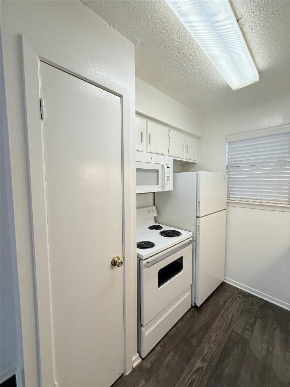 2704 Salado St Unit 207, Austin, TX 78705 - kitchen featuring white appliances, dark wood-style flooring, white cabinetry, and a textured ceiling