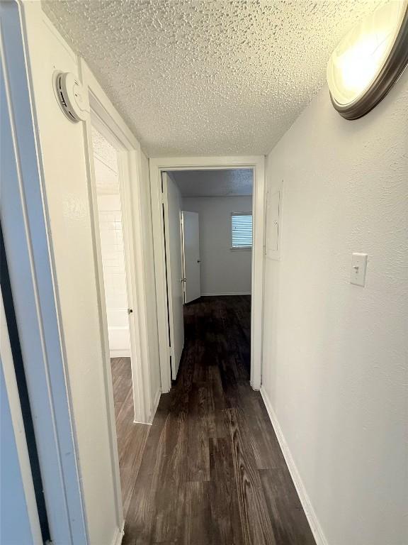 2704 Salado St Unit 207, Austin, TX 78705 - corridor with dark wood finished floors and a textured ceiling