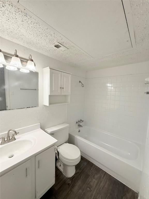 2704 Salado St Unit 207, Austin, TX 78705 - full bathroom with wood finished floors, vanity, shower / bathtub combination, and a textured ceiling