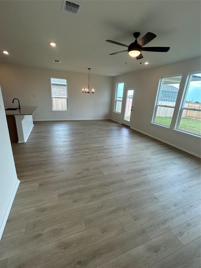 15101 Onager Pass, Manor, TX 78653 - spare room featuring a chandelier, wood finished floors, ceiling fan, and recessed lighting