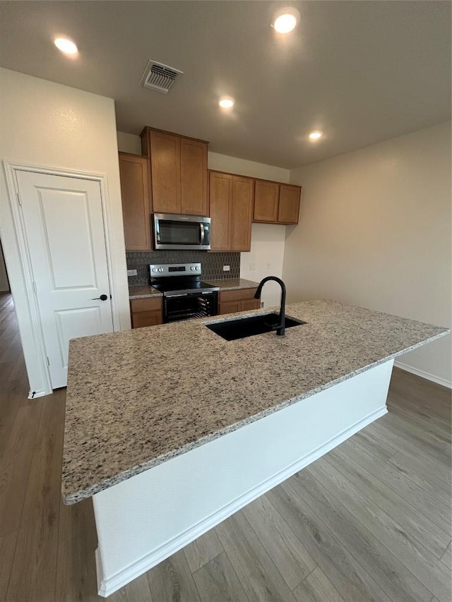 15101 Onager Pass, Manor, TX 78653 - kitchen featuring electric range oven, stainless steel microwave, dark wood-style floors, light stone counters, and recessed lighting