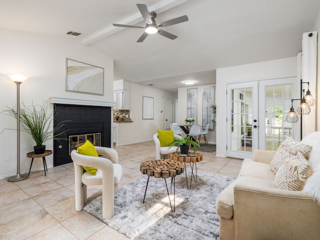 12919 Margit Dr, Austin, TX 78729 - living room featuring light tile patterned floors, ceiling fan, a tiled fireplace, and french doors
