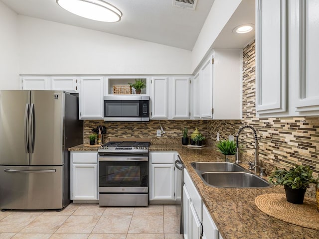 12919 Margit Dr, Austin, TX 78729 - kitchen featuring appliances with stainless steel finishes, vaulted ceiling, backsplash, white cabinets, and recessed lighting
