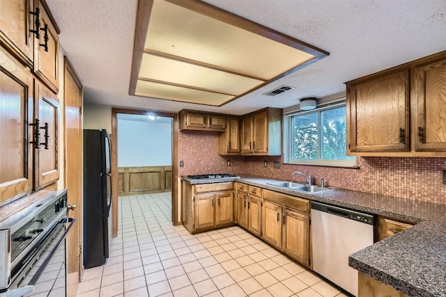 6819 Bayridge Ter, Austin, TX 78759 - kitchen featuring stainless steel appliances, dark countertops, light tile patterned floors, decorative backsplash, and a textured ceiling