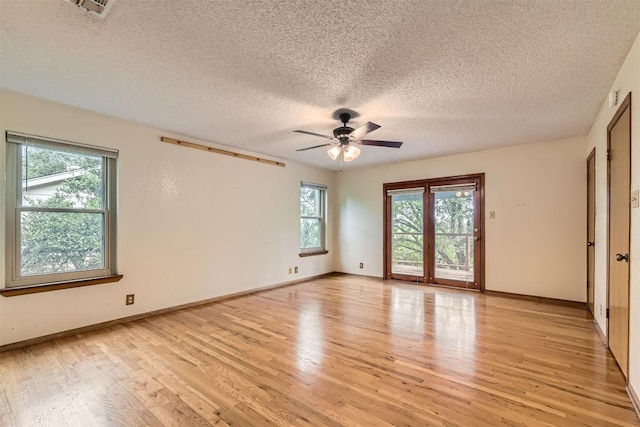 6819 Bayridge Ter, Austin, TX 78759 - empty room with plenty of natural light, light wood finished floors, ceiling fan, and a textured ceiling