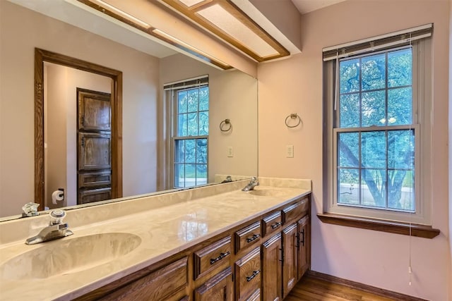 6819 Bayridge Ter, Austin, TX 78759 - full bathroom with double vanity, plenty of natural light, and wood finished floors
