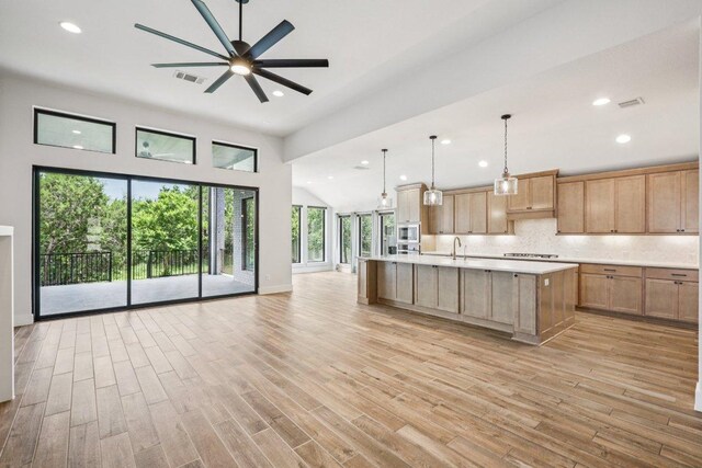 412 Pin Cherry Pass, San Marcos, TX 78666 - kitchen featuring open floor plan, light countertops, cooktop, a ceiling fan, and light wood-style flooring