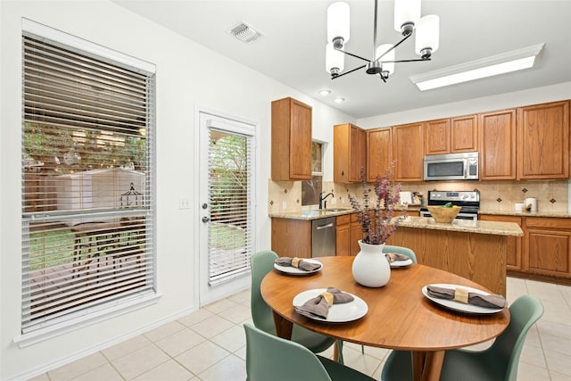 11024 Mint Julep Dr, Austin, TX 78748 - kitchen with stainless steel appliances, light tile patterned floors, a chandelier, and backsplash