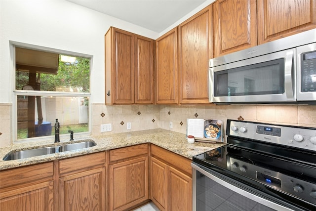 11024 Mint Julep Dr, Austin, TX 78748 - kitchen with stainless steel appliances, light stone countertops, tasteful backsplash, and brown cabinets