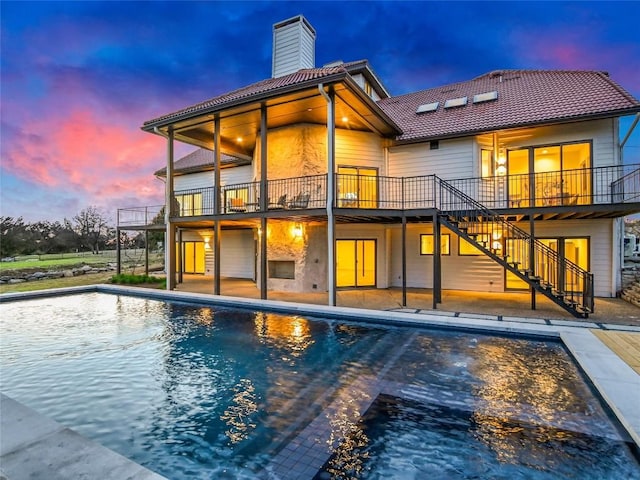 3901 Peak Lookout Dr, Austin, TX 78738 - back of house featuring stairs, a tile roof, a chimney, an outdoor pool, and a patio