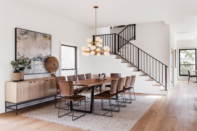 3901 Peak Lookout Dr, Austin, TX 78738 - dining area featuring hardwood / wood-style floors, stairway, and a chandelier