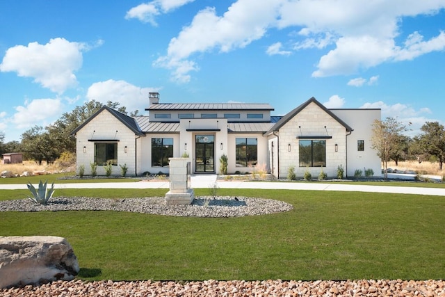 439 Junker Hl, Fredericksburg, TX 78624 - view of front facade featuring french doors, a standing seam roof, a front lawn, and a chimney
