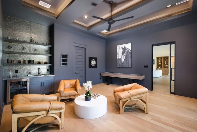 439 Junker Hl, Fredericksburg, TX 78624 - living area featuring wine cooler, bar with sink, light wood-type flooring, recessed lighting, and beam ceiling