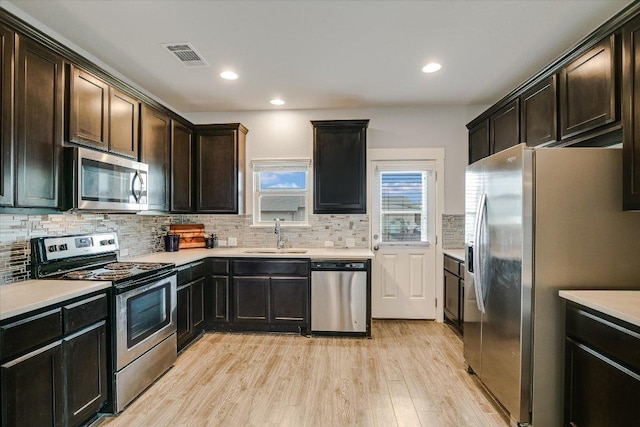 132 Ancellotta Way, Leander, TX 78641 - kitchen featuring appliances with stainless steel finishes, light wood-type flooring, backsplash, light countertops, and recessed lighting