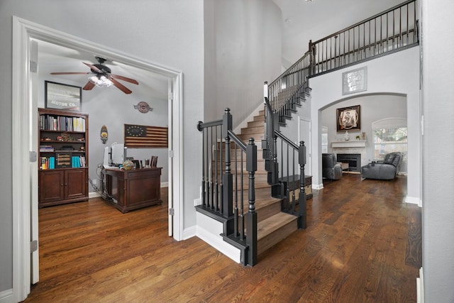 15413 Echo Hills Dr, Austin, TX 78717 - stairs with a fireplace, a ceiling fan, wood finished floors, arched walkways, and a high ceiling
