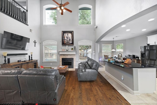15413 Echo Hills Dr, Austin, TX 78717 - living room featuring ceiling fan, a towering ceiling, a stone fireplace, arched walkways, and recessed lighting