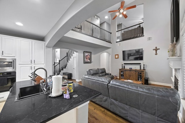 15413 Echo Hills Dr, Austin, TX 78717 - living area featuring arched walkways, ceiling fan, stairs, dark wood finished floors, and recessed lighting