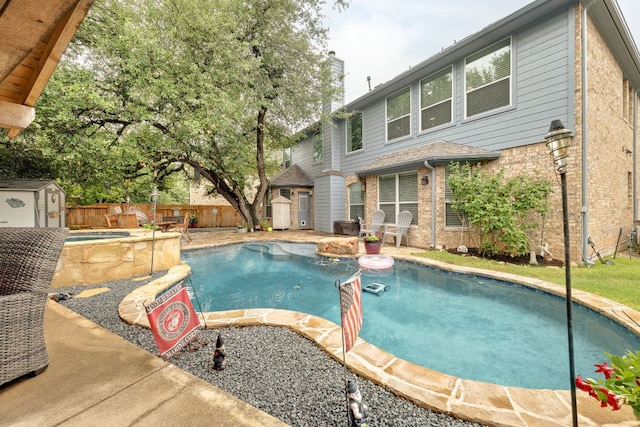 15413 Echo Hills Dr, Austin, TX 78717 - view of swimming pool with a storage unit, a fenced backyard, an in-ground hot tub, and a patio