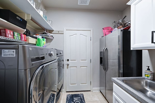 15413 Echo Hills Dr, Austin, TX 78717 - laundry area featuring washing machine and clothes dryer, light tile patterned floors, and cabinet space