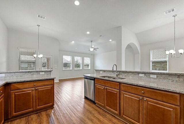 2344 Broken Wagon Dr, Leander, TX 78641 - kitchen featuring dishwasher, a chandelier, backsplash, brown cabinets, and recessed lighting