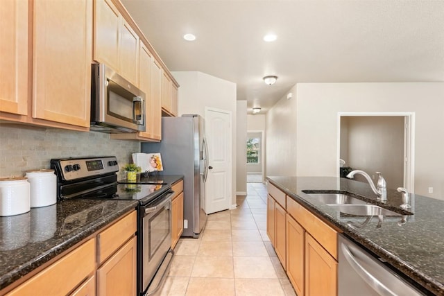 19105 Obed River Dr, Pflugerville, TX 78660 - kitchen with stainless steel appliances, tasteful backsplash, light tile patterned floors, dark stone countertops, and recessed lighting