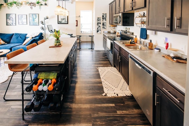 8601 W Gate Blvd Unit 4103, Austin, TX 78745 - kitchen featuring appliances with stainless steel finishes, light countertops, dark wood-type flooring, and open floor plan