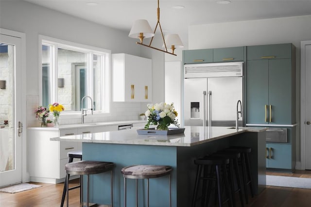 114 Medalist St, Lakeway, TX 78734 - kitchen featuring stainless steel built in fridge, a kitchen bar, a center island, wood finished floors, and recessed lighting