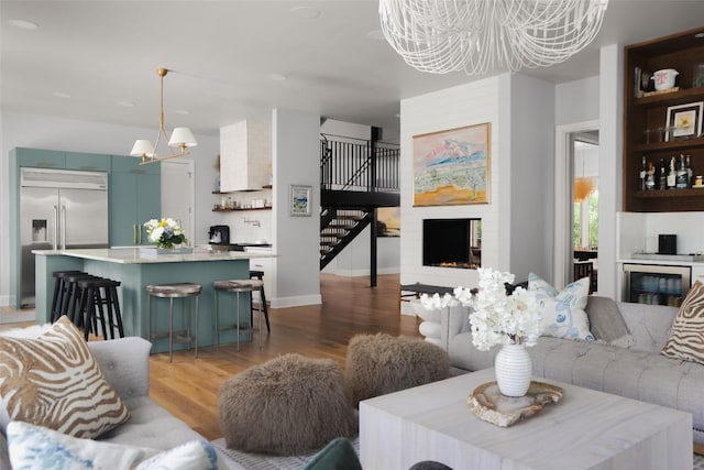 114 Medalist St, Lakeway, TX 78734 - living area with a chandelier, beverage cooler, stairway, and light wood-type flooring