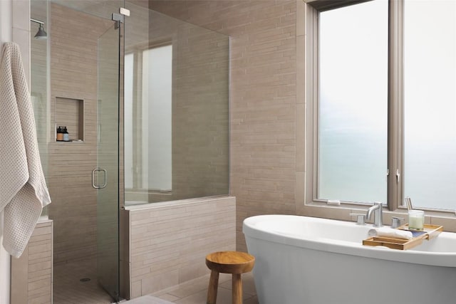 114 Medalist St, Lakeway, TX 78734 - bathroom with a shower stall, a freestanding tub, and tile walls