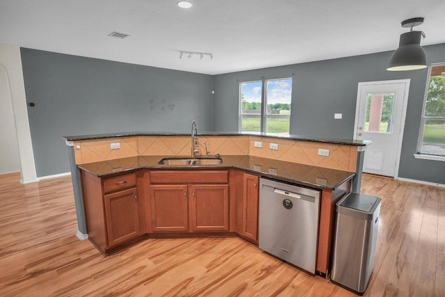 123 Brittany Ln, Bastrop, TX 78602 - kitchen with dishwasher, light wood-type flooring, brown cabinets, tasteful backsplash, and healthy amount of natural light
