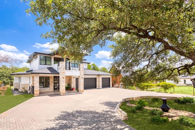 14430 Tuscola Cir, Austin, TX 78734 - view of front of property featuring a balcony, stone siding, a garage, and decorative driveway