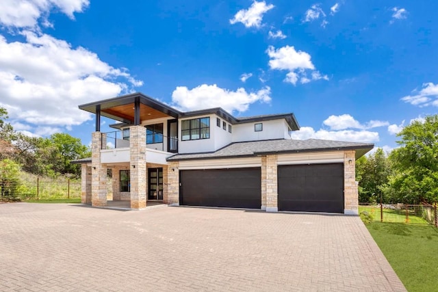 14430 Tuscola Cir, Austin, TX 78734 - contemporary house featuring a balcony, decorative driveway, stone siding, a garage, and stucco siding