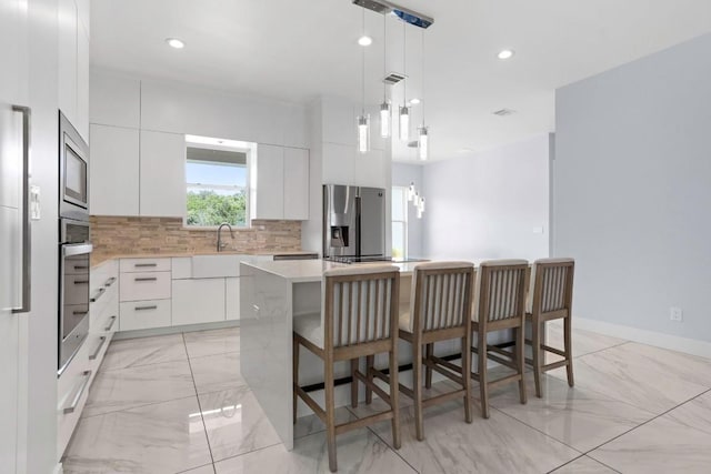 14430 Tuscola Cir, Austin, TX 78734 - kitchen featuring appliances with stainless steel finishes, modern cabinets, a center island, tasteful backsplash, and recessed lighting