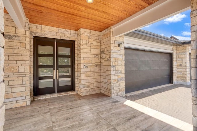 14430 Tuscola Cir, Austin, TX 78734 - doorway to property featuring a garage, french doors, stone siding, and driveway