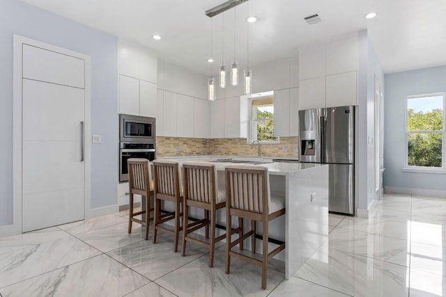 14430 Tuscola Cir, Austin, TX 78734 - kitchen with stainless steel appliances, modern cabinets, backsplash, a kitchen breakfast bar, and recessed lighting