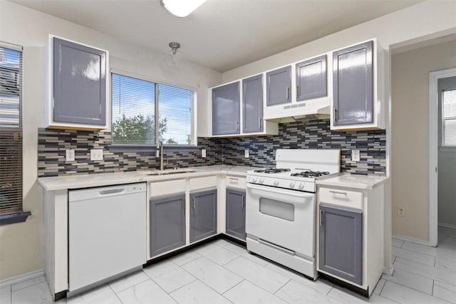 161 Prairie Verbena Dr, Kyle, TX 78640 - kitchen with white appliances, under cabinet range hood, gray cabinetry, backsplash, and light countertops