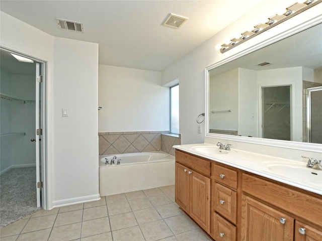 106 S Gadwall Ln, Cedar Park, TX 78613 - bathroom featuring a spacious closet, double vanity, tile patterned floors, a garden tub, and a shower stall