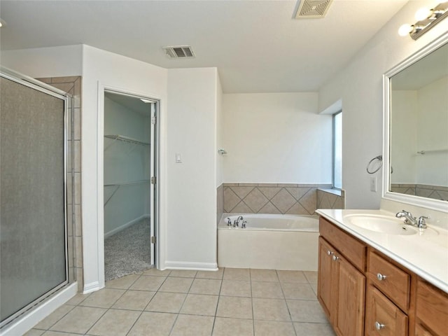 106 S Gadwall Ln, Cedar Park, TX 78613 - bathroom featuring tile patterned floors, a stall shower, vanity, a garden tub, and a walk in closet
