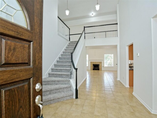 106 S Gadwall Ln, Cedar Park, TX 78613 - foyer entrance featuring light tile patterned floors, stairs, a fireplace, and a towering ceiling