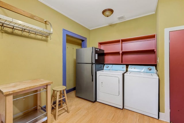 2834 Pearl St, Austin, TX 78705 - laundry area with light wood-style flooring, crown molding, and washer and clothes dryer