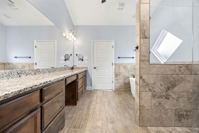 2660 Cowgirl Trl, Belton, TX 76513 - full bathroom with a freestanding tub, vanity, wood finished floors, tile walls, and wainscoting