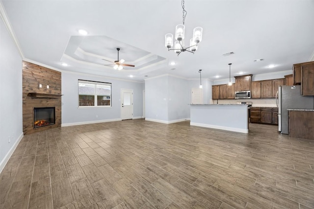 2660 Cowgirl Trl, Belton, TX 76513 - unfurnished living room with a ceiling fan, a tray ceiling, recessed lighting, wood finished floors, and a fireplace