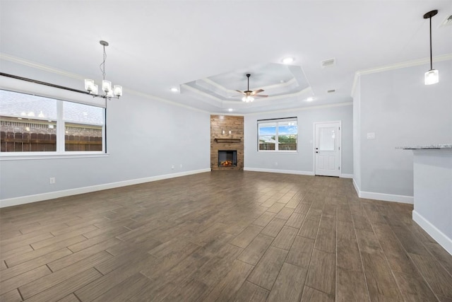 2660 Cowgirl Trl, Belton, TX 76513 - unfurnished living room with a tray ceiling, ornamental molding, dark wood-style floors, a ceiling fan, and a chandelier